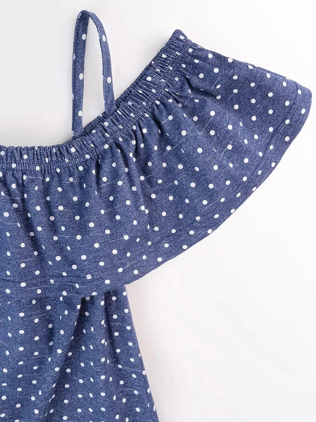 Close-up of the off-shoulder ruffle detail of the blue polka dot cotton Scarlett Mini Dress by Lauven.