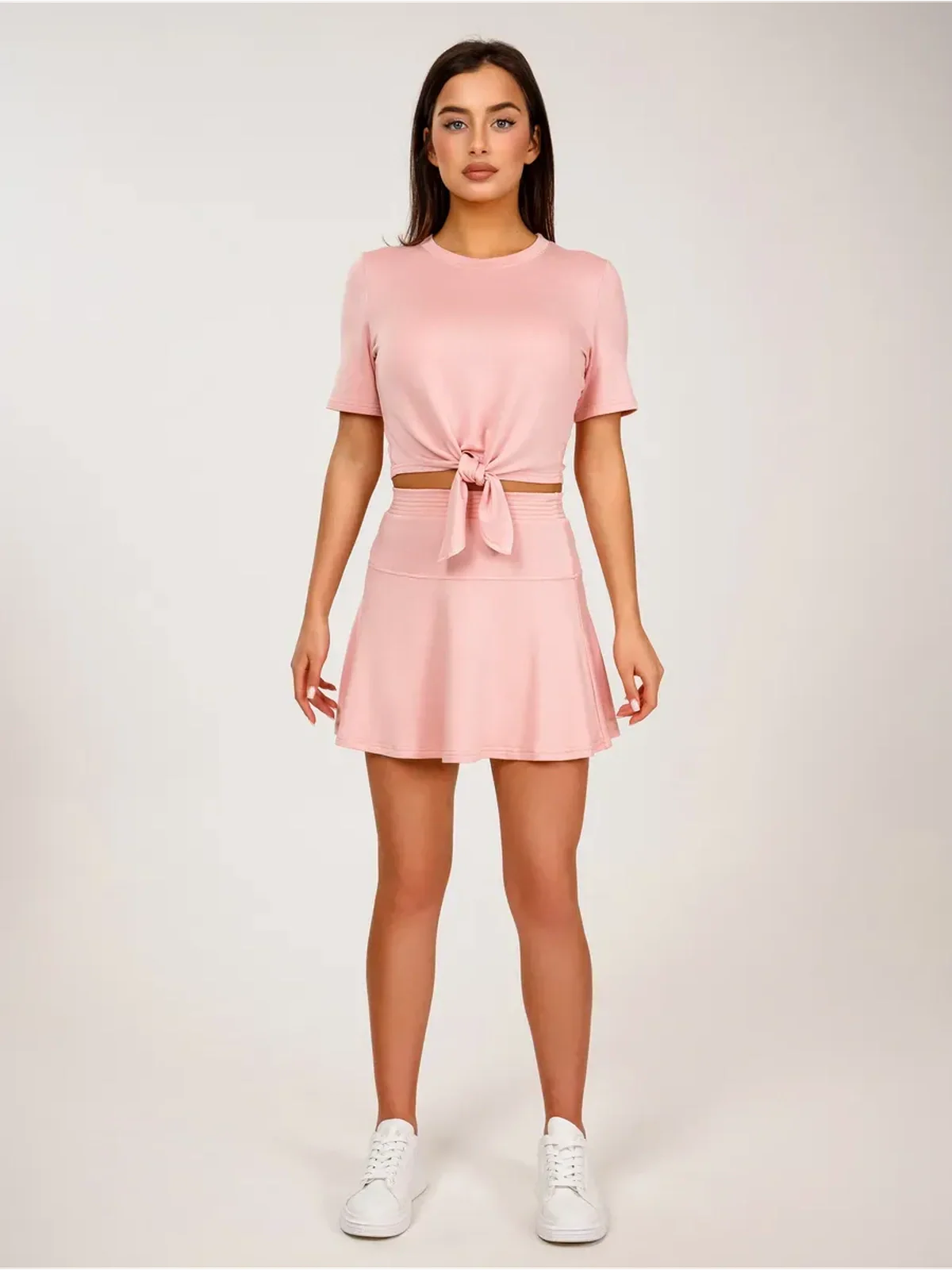 Serena Set women's two-piece cropped top and mini skirt in soft pink, featuring tie-front detail and flared design.