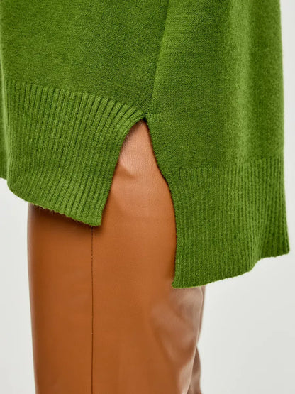 Close-up of the Siena Sweater by Lauven showing the unique split hem detail against brown pants.