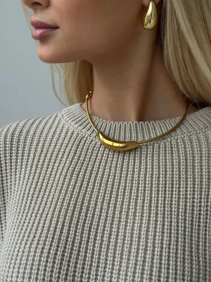 Close-up of a model wearing the Sierra Sweater and golden jewelry, showcasing a chic and stylish look.