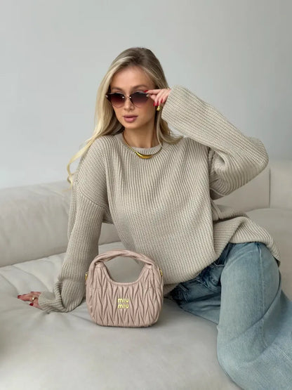 Model wearing a Sierra Sweater by Lauven, oversized beige knit with crew neck, paired with a stylish bag.