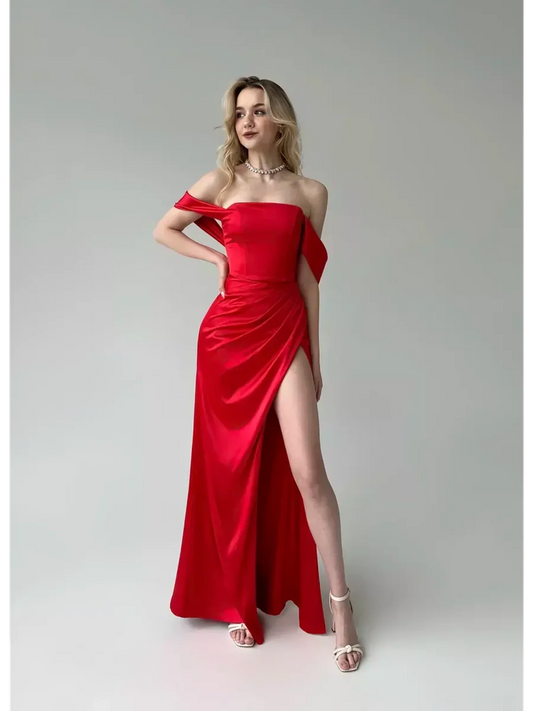 Model wearing a stunning Lauven Vega Party Dress, a red satin off-shoulder gown featuring elegant draping and a high slit.