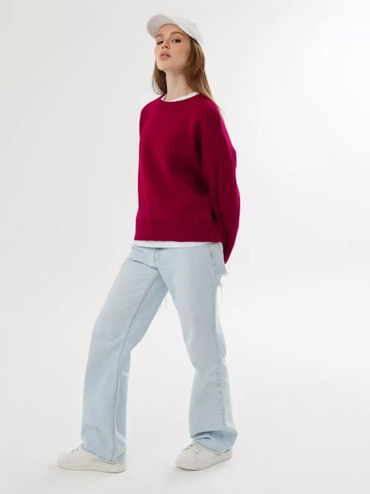 Model wearing Vela Pullover in burgundy with light denim and sneakers, showcasing Lauven brand style.