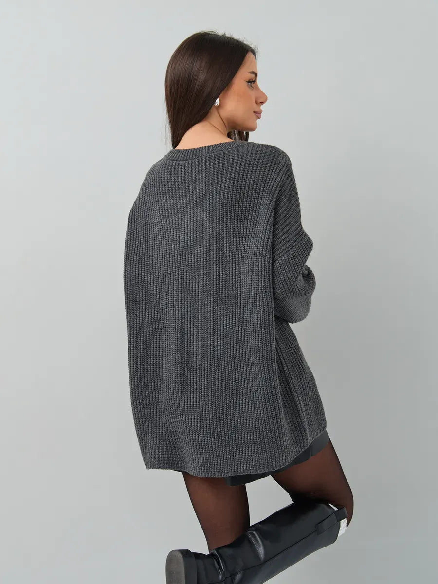 Back view of a woman wearing the Vera Sweater by Lauven in oversized dark gray knit.