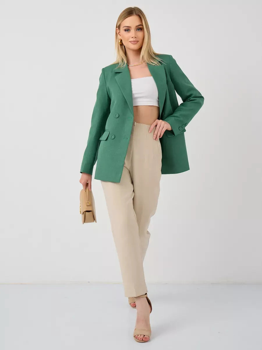 Model wearing the Verde Blazer from Lauven, an oversized double-breasted green tailored jacket styled with beige trousers.