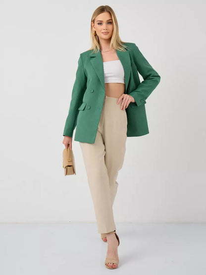 Model wearing the Verde Blazer from Lauven, an oversized double-breasted green tailored jacket styled with beige trousers.