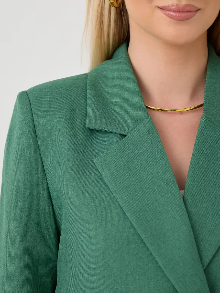 Close-up of the Verde Blazer by Lauven, showcasing its elegant green fabric and tailored double-breasted design.
