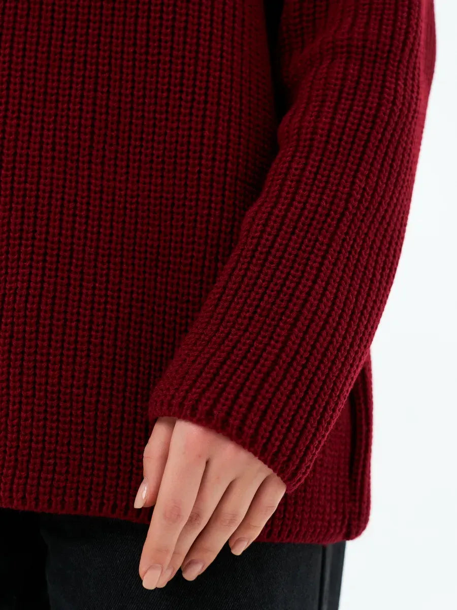 Close-up of the sleeve detail of the Verona Sweater by Lauven in deep burgundy knit, showcasing its oversized design.