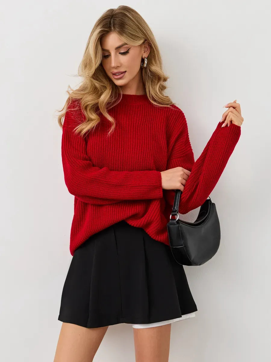 Viona Sweater by Lauven — Oversized red knit with crew neck, styled with a black skirt and handbag.