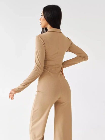 Jersey Jumpsuit showcasing a woman in a sand ribbed knit fabric with a button-front and wide-leg silhouette from the back.