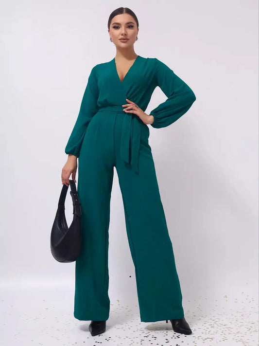 Zoe Jumpsuit in teal with wide legs, belted waist, and long sleeves, styled for a chic look.
