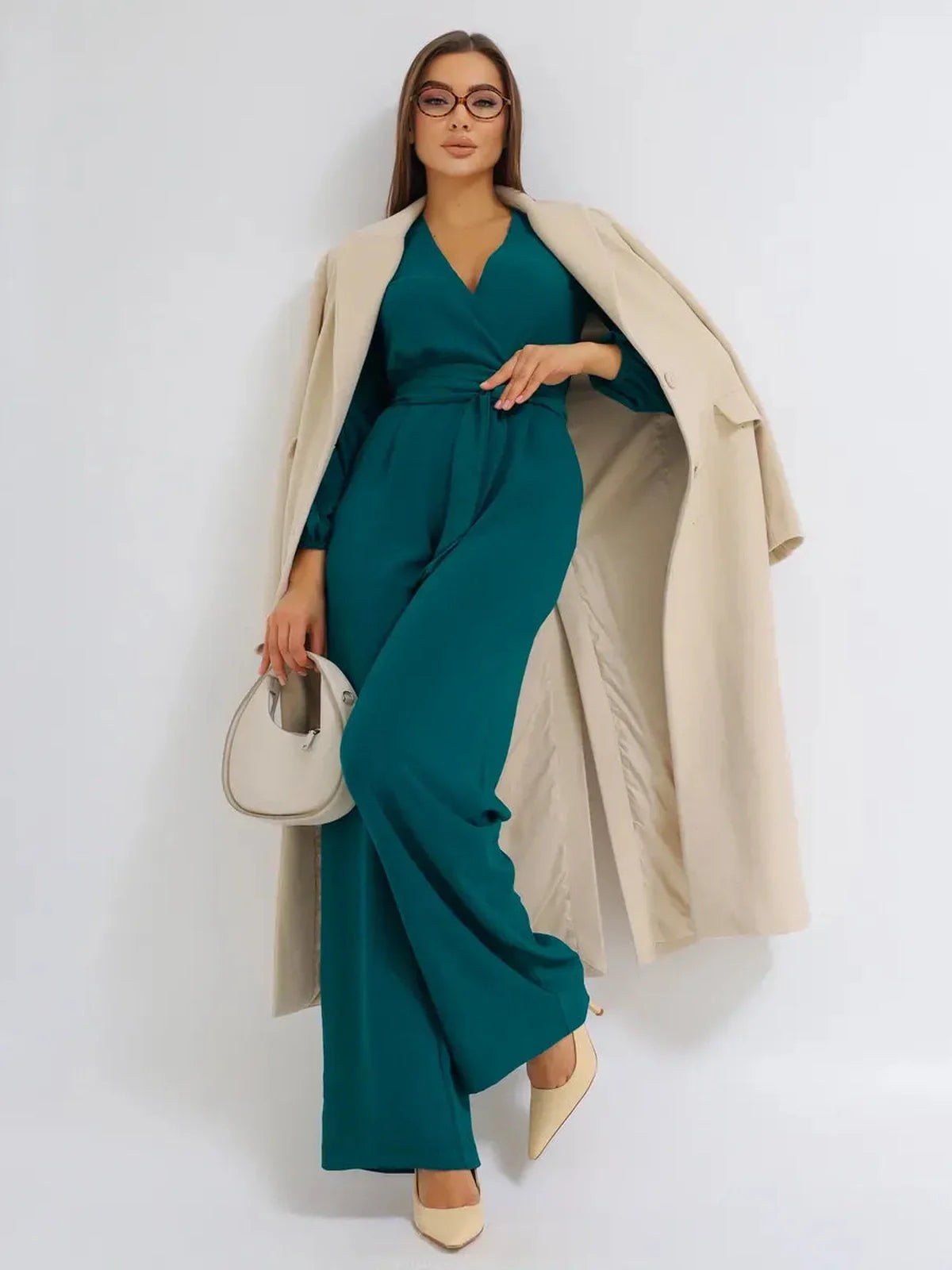 Model showcasing the Zoe Jumpsuit with a deep V-neckline, belted waist, and wide-leg silhouette.