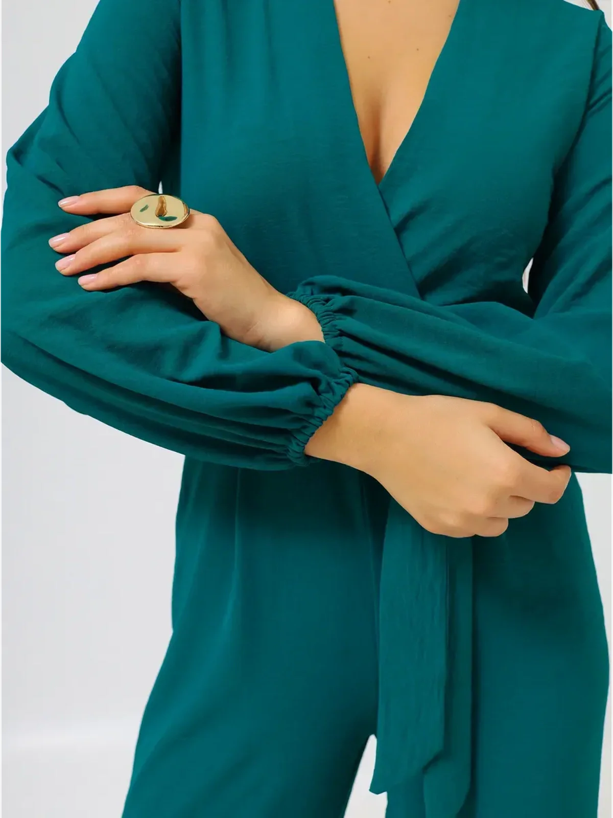 Detail view of the Zoe Jumpsuit featuring a deep V-neckline and voluminous sleeves.
